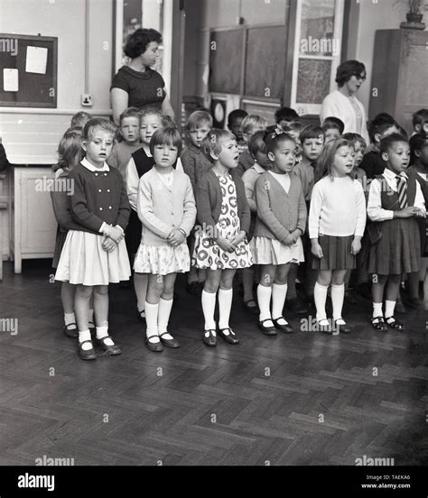 1960s Historical Infant School Children Standing Singing Together At