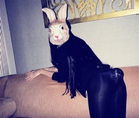 A Woman Sitting On Top Of A Couch With A Bunny Mask On Her Head And