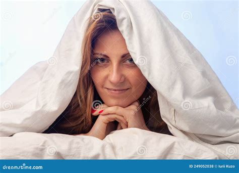 Beautiful Woman Wake Up And Lying In Bed Under A Blanket Stock Photo