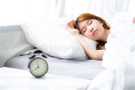Closeup Alarm Clock And Beautiful Asian Young Woman In Morning Stock