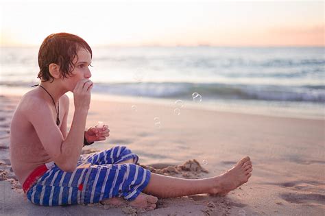 Boy Blowing Bubbles At The Beach At Sunset By Stocksy Contributor Angela Lumsden Stocksy