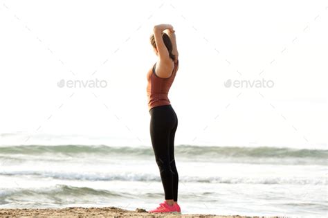 Full Length Beautiful Runner Stretching Muscles After Workout On Beach