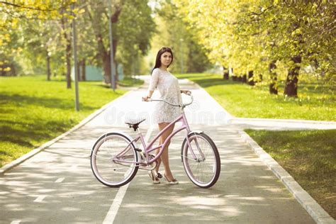Ragazza In Prendisole Che Guidano Una Bicicletta In Parco Fotografia Stock Immagine Di Modo