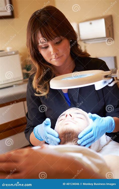 Beautician Applying Cream To Male Client In Clinic Stock Photo Image