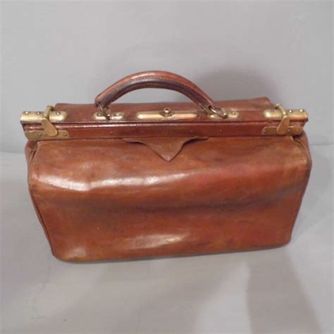 A bag like a briefcase having two equal compartments joined by a hinge. Vintage Gladstone Bag - Travers Antiques