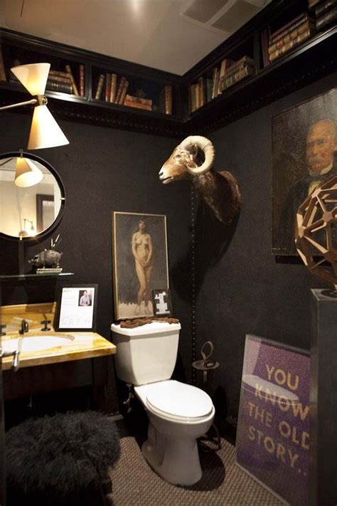 A Bathroom With Black Walls And Pictures On The Wall