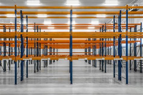 Empty Orange Warehouse Shelves In Grey Industrial Interior Stock Image