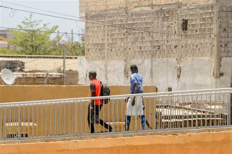Unidentified Senegalese Men Walk Along The Bridge In Dakar The