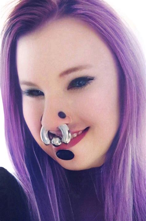 A Woman With Purple Hair Wearing A Nose Ring And Piercings On Its Nose