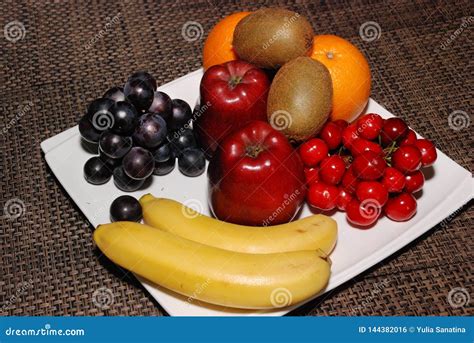 Oranges Apples Grapes Kiwis Cherries Bananas On The White Plate On