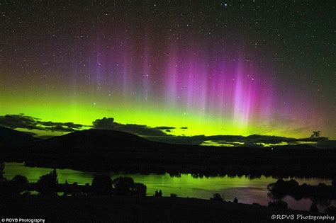 An Image Of The Aurora Bore In The Night Sky Over A Lake And Mountain Range