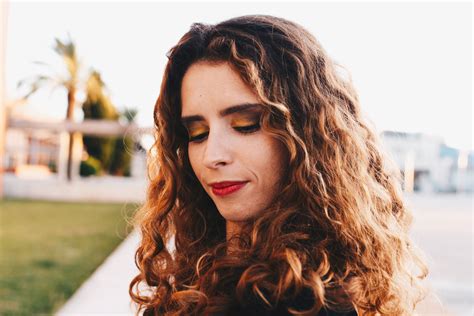 Free Photo Curly Brown Haired Woman Wearing Black Shirt With Red Lipstick Looking Down