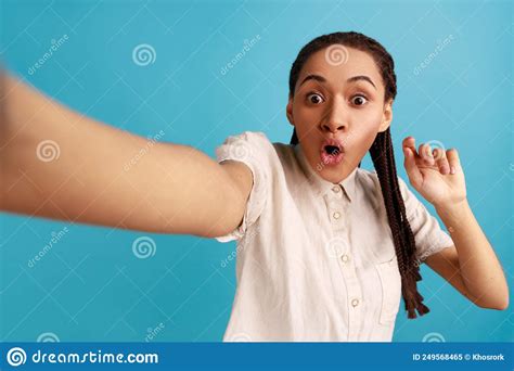 woman making selfie looking at camera with big eyes and open mouth point of view photo stock