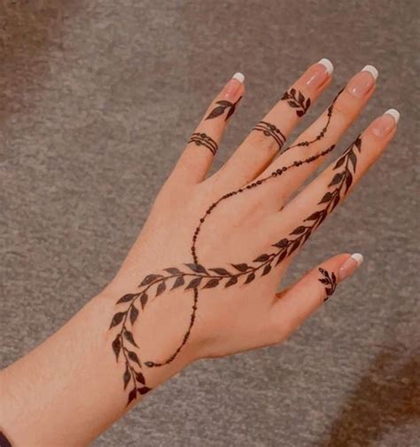 A Woman S Hand With Hennap Tattoos On Her Left Wrist And Fingers
