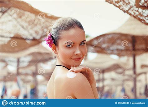Beautiful Young Woman In Bikini Smear Protective Cream On The Skin On The Beach Under The Sun
