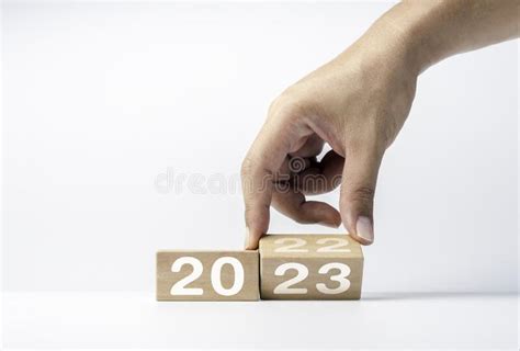 Close Up Hand Flipping The 2022 To 2023 Year Numbers Calendar On Wooden