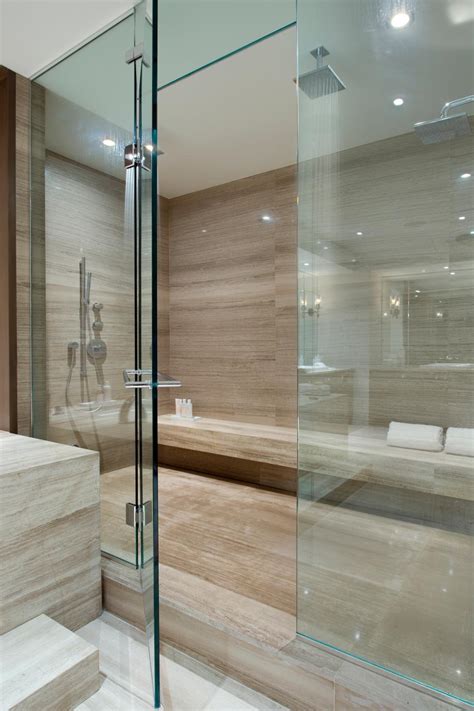 The room's crisp white palette carries into the master bedroom, creating a sense of cohesion. Enormous Marble Walk-in Shower with Glass Doors | HGTV