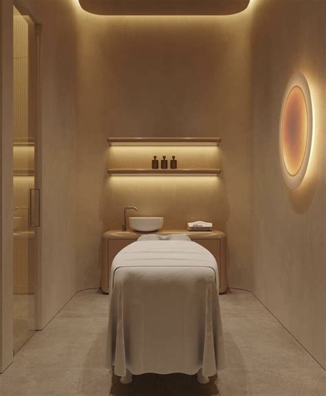 A Spa Room With A White Bed And Round Lights On The Wall Above Its Head