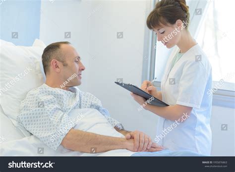 Nurse Asking Questions On Recovering Patient Stock Photo 1955876863
