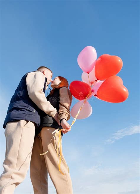 Cheerful Romantic Couple Dating And Kissing Outdoors With Balloons