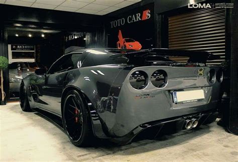 A Black Sports Car Parked In Front Of A Garage