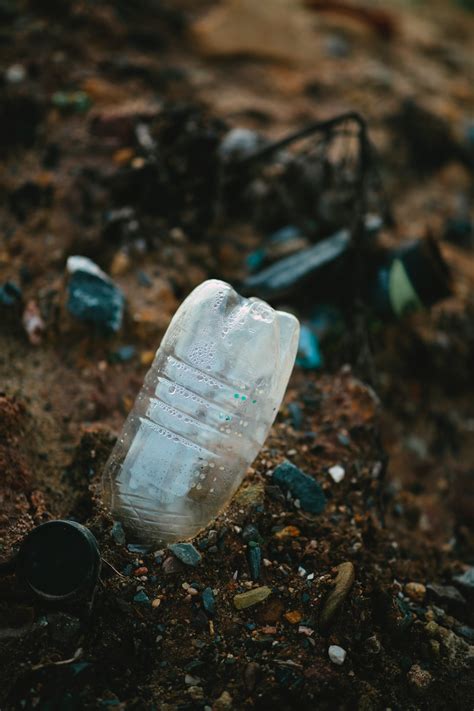 White Plastic Bottle On Brown Soil Photo Free Pollution Image On Unsplash