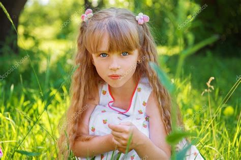 Cute Little Girl Sitting On The Grass On A Summer Sunny Day ⬇ Stock