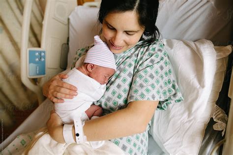 Mother Holds Newborn Baby In Hospital Bed By Stocksy Contributor Maria Manco Stocksy