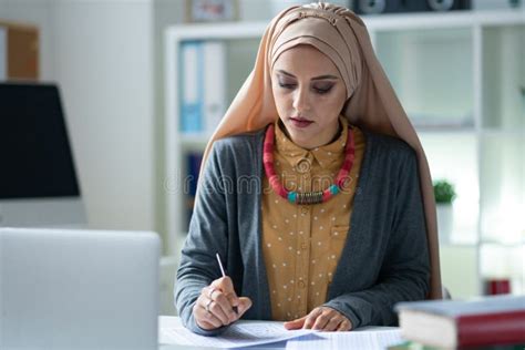 Stylish Muslim Teacher Wearing Hijab Feeling Busy Correcting Tests