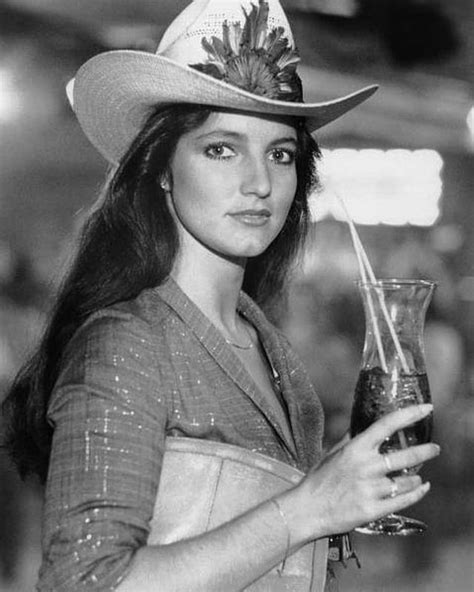 A Woman In A Cowboy Hat Holding A Drink
