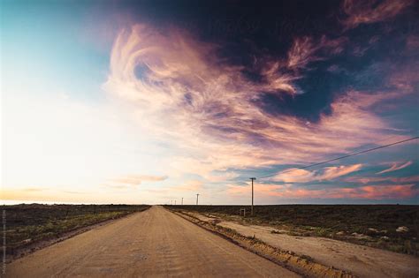 Long Dirt Road Into The Horizon At Sunset By Stocksy Contributor