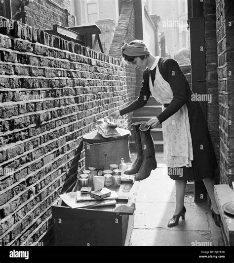 a british housewife puts out items for salvage during 1942 a housewife puts a pair of old