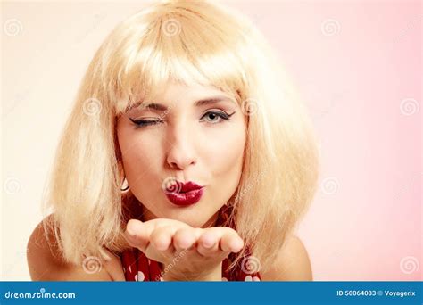 Menina Do Pinup No Vestido Retro Da Peruca Loura Que Funde Um Beijo