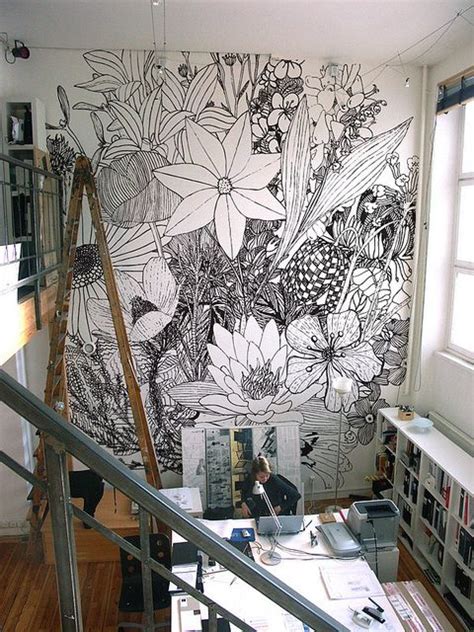The Wall Is Decorated With Black And White Flowers In An Art Studio
