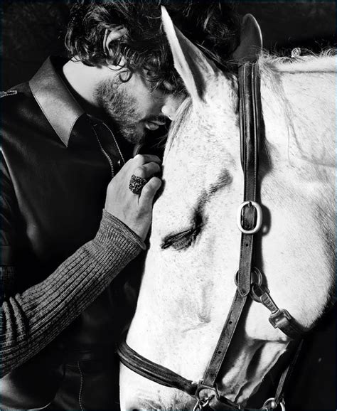 A Man Is Kissing The Nose Of A White Horse
