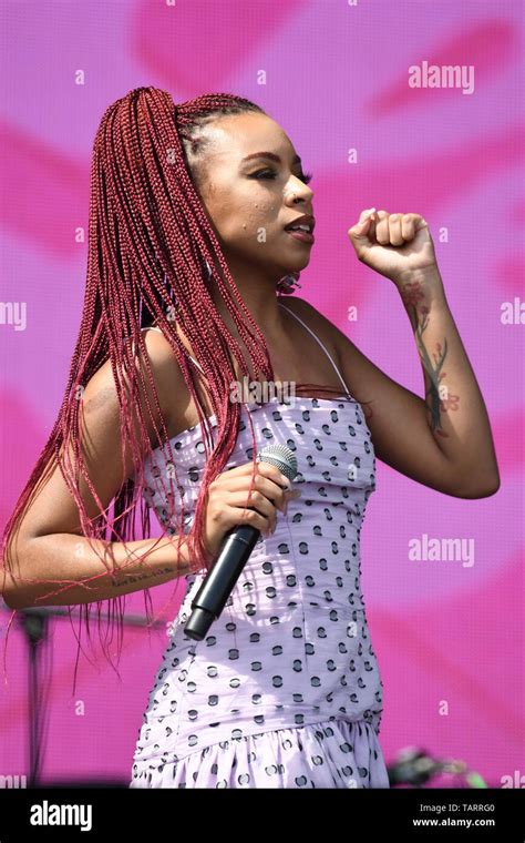 Singer Ravyn Lenae Is Shown Performing On Stage During A Live Concert