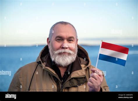 man holding netherlands flag portrait of older man with a national dutch flag visit