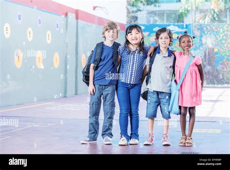 Schoolchildren Embracing Happy Multi Cultural Racial Classroom Stock