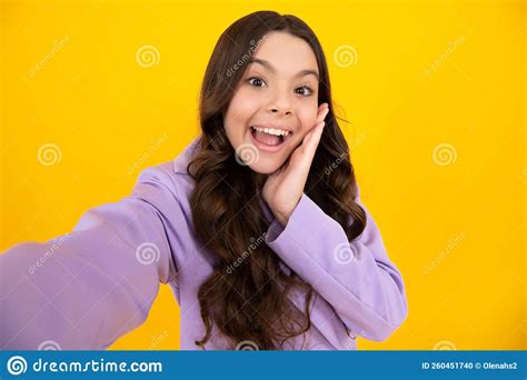 jovencita graciosa haciendo selfie posando sobre fondo amarillo feliz adolescente con emociones