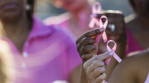 multiracial hands holding breast cancer awareness ribbon augusta alumnae chapter