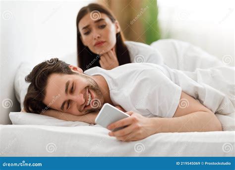 Wife Spying While Cheating Husband Texting On Cellphone In Bedroom Stock Image Image Of
