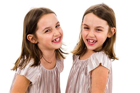 Premium Photo Close Up Portrait Of Smiling Twins Standing Against