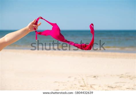 Close Up Of Young Woman Taking Off Her Bra At Nude Beach Concept Of