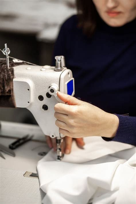 Seamstress Sews Clothes On A Sewing Machine In Her Studio Close Up