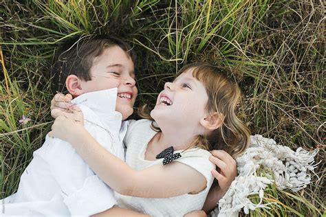 A Brother And Sister Hug On The Ground By Stocksy Contributor Alison