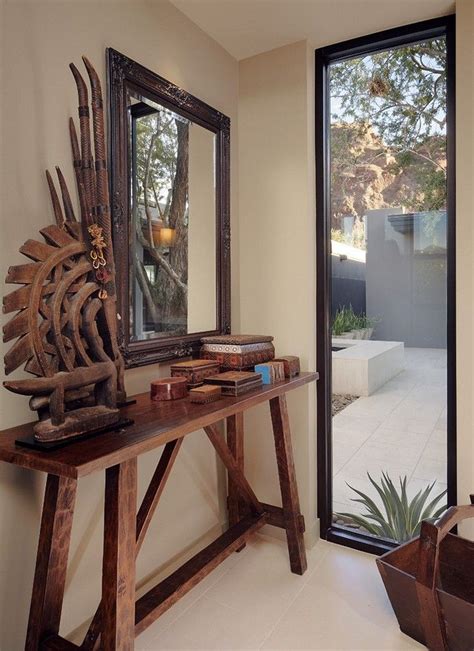 A Wooden Table Topped With A Mirror Next To A Window