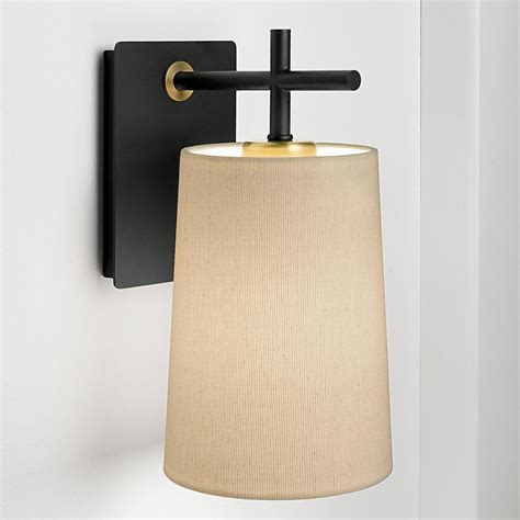 A Satin Black Wall Light With Design Elements In Brushed Brass A