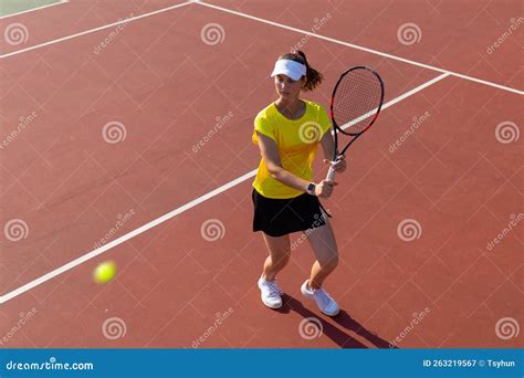 professional equipped female tennis player beating hard the tennis ball with racquet top view