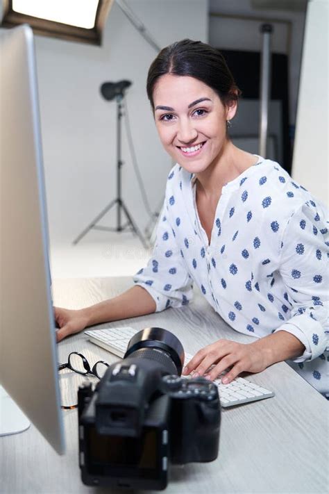 Portrait Of Female Photographer In Studio Reviewing Images From Photo