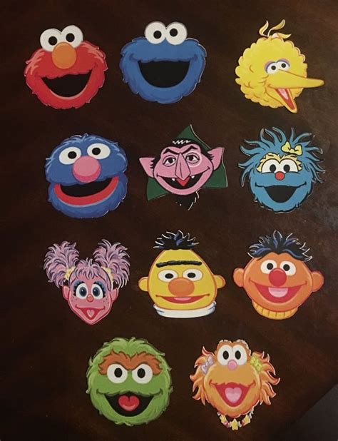 An Assortment Of Sesame Street Characters Are Shown On A Wooden Table